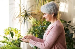 happy woman taking care of her houseplants