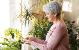 happy woman taking care of her houseplants
